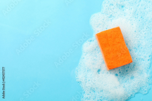 Orange sponge and foam on blue background photo