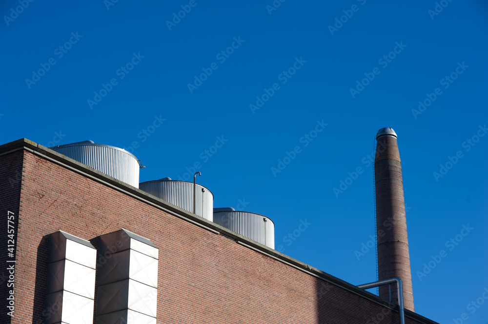 Obraz premium Aarhus, Denmark - 2021 - Industrial plant chimneys against a blue sky