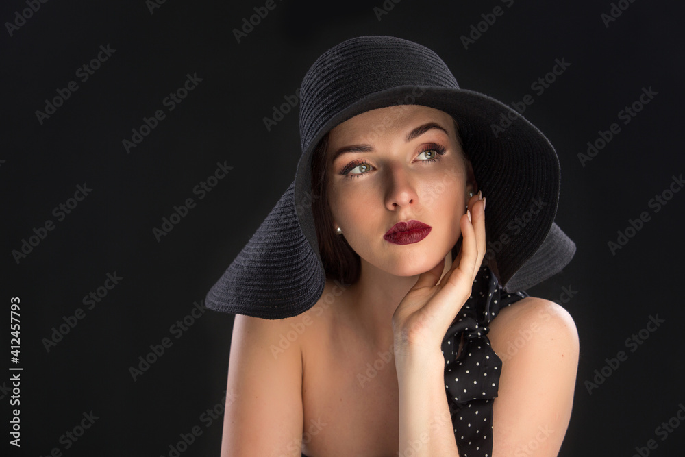 fashion portrait of a young and very beautiful girl in a black hat on a black background fashion portrait of a young and very beautiful girl in a black hat on a black background