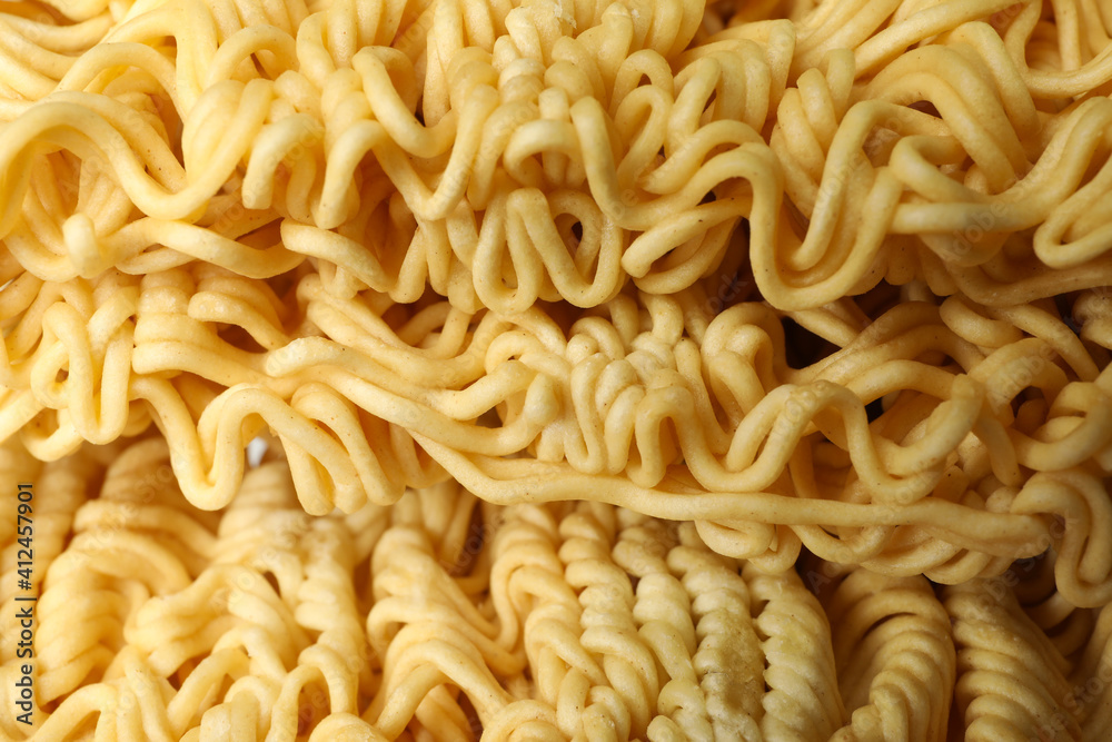 Uncooked instant noodles on whole background, close up Uncooked instant noodles on whole background, close up