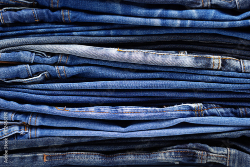 Stack or pile of denim jeans as background texture