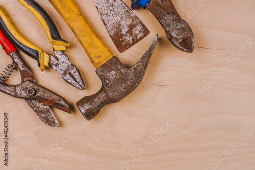 Old and rusty hand tools . Work background on wooden board