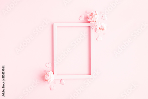 Valentine's Day background. Photo frame, pink flowers, hearts on pastel pink background. Valentines day concept. Flat lay, top view, copy space © Flaffy