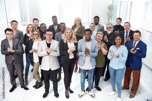 group of diverse corporate employees applauding together .