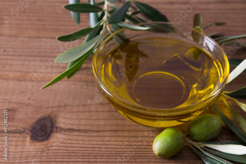 glass vessel with extra virgin olive oil and olives with branch