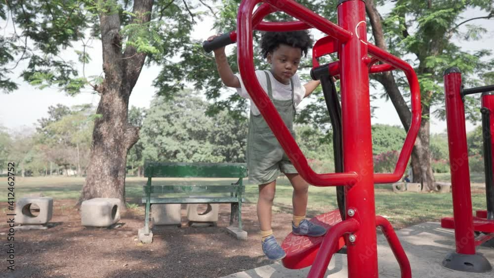 black people child playing exercise machine in the park black people child playing exercise machine in the park