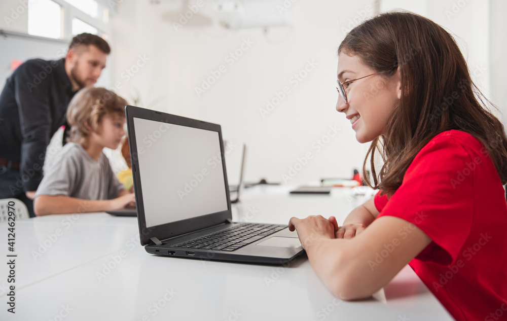 Happy girl using laptop during lesson Happy girl using laptop during lesson