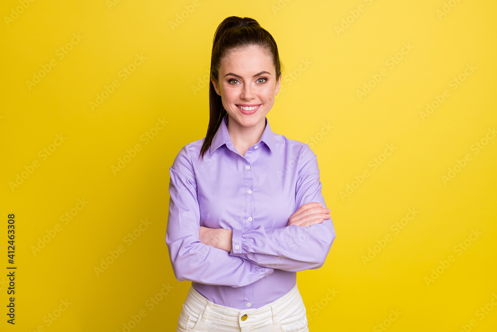 Photo portrait of confident woman with folded arms isolated on bright yellow colored background Photo portrait of confident woman with folded arms isolated on bright yellow colored background