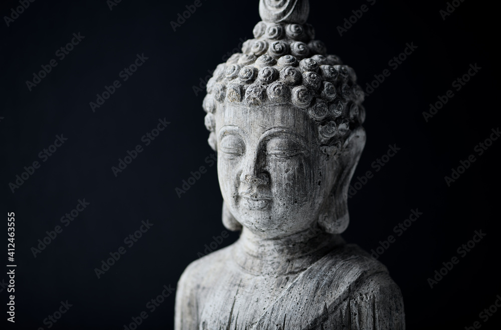 Meditating Buddha Statue on dark background. Close up. Copy space.	
