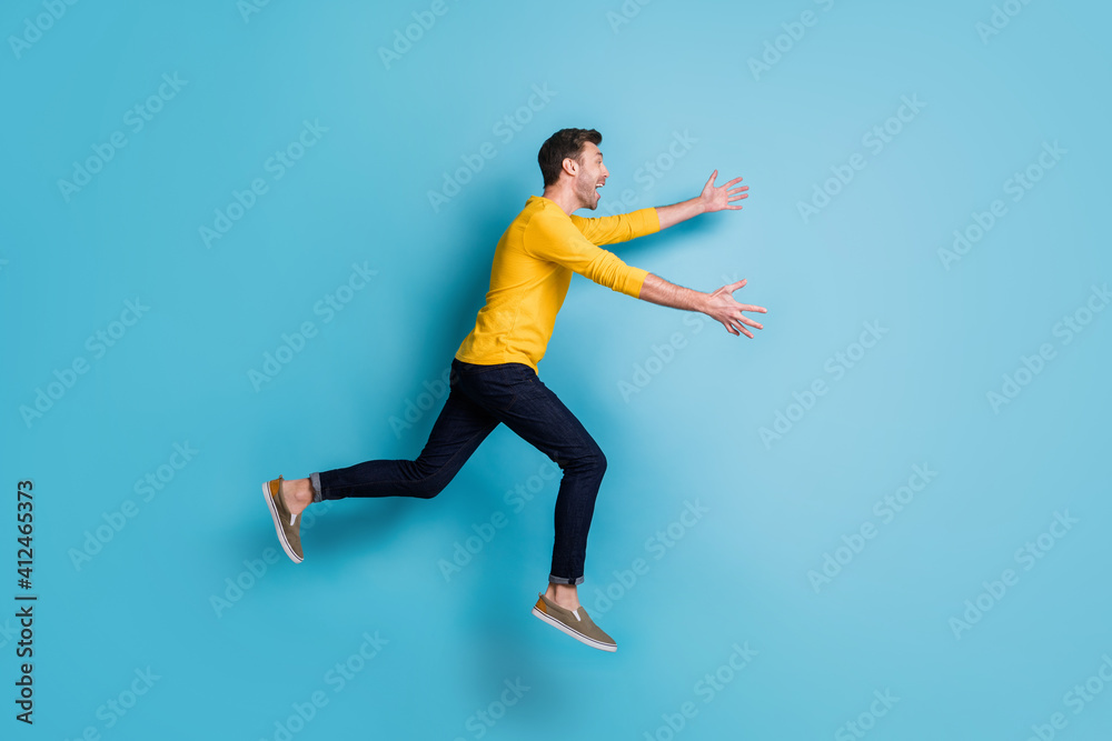 Full body profile side photo of cheerful man run jump sale open hands wear casual clothes isolated on blue color background
