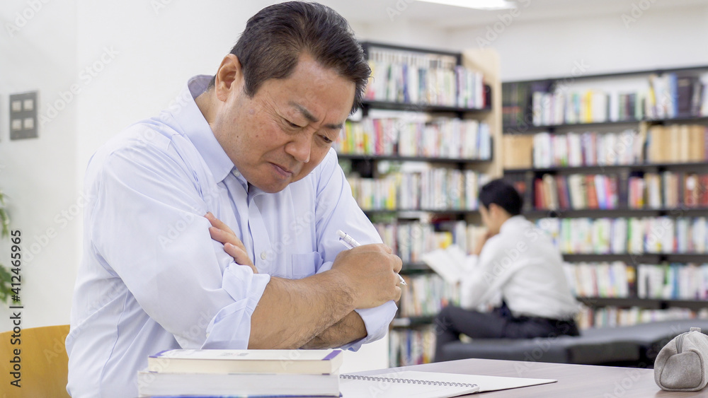 図書館で勉強する中高年男性 図書館で勉強する中高年男性