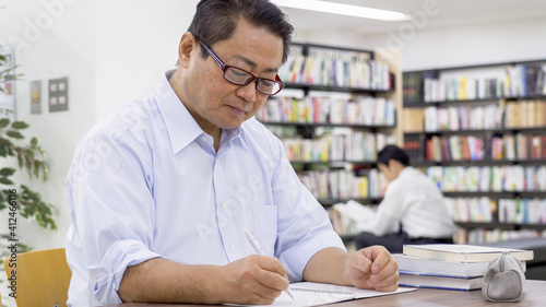 図書館で勉強する中高年男性