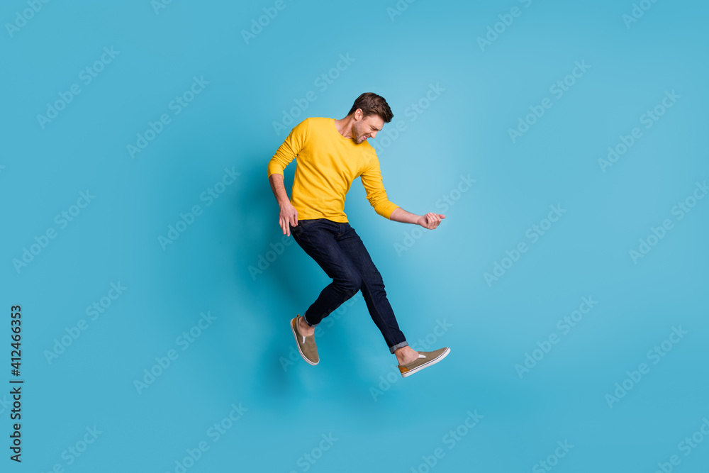 Full length body size view of nice funny cool cheerful guy jumping playing invisible guitar isolated over bright blue color background