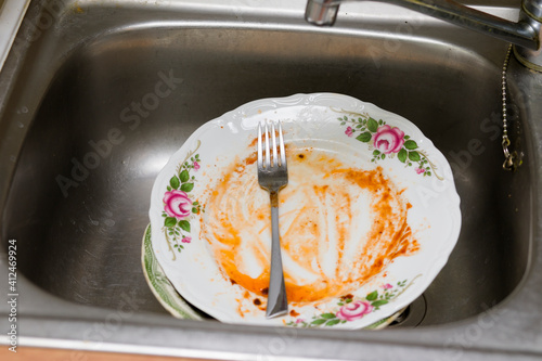 Dirty, unwashed dishes in the kitchen and sink