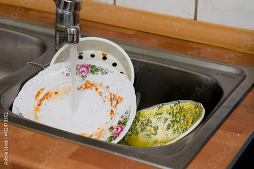 Dirty, unwashed dishes in the kitchen and sink