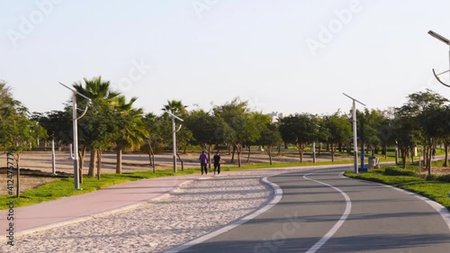 Jogging and cycling tracks in Al Warqa park, Dubai, UAE early in the morning. Lamp post powered by solar panels can be seen in the picture. Outdoors photo
