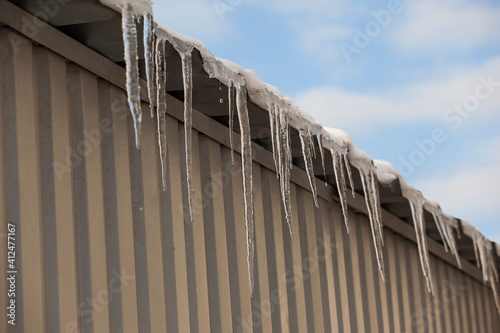 winter icicles hanging from the roof of the building