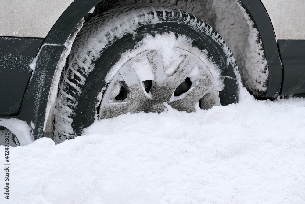 Snow covered car in an open parking Snow covered car in an open parking