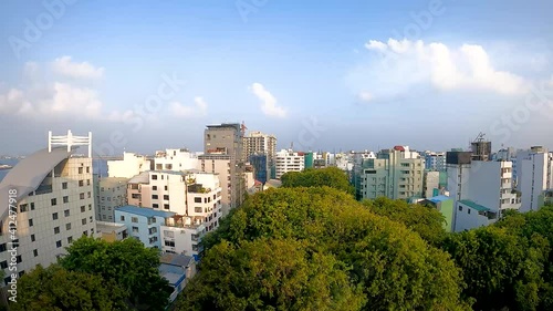 Timelapse of Male (Malé) skyline, capital city of Maldives, sunset and getting dark over the city, boats and aircraft moving in the background, city life.