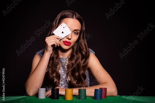 Photo of serious fancy lady sit poker table hold two ace cards cover eye wear glossy dress isolated black color background