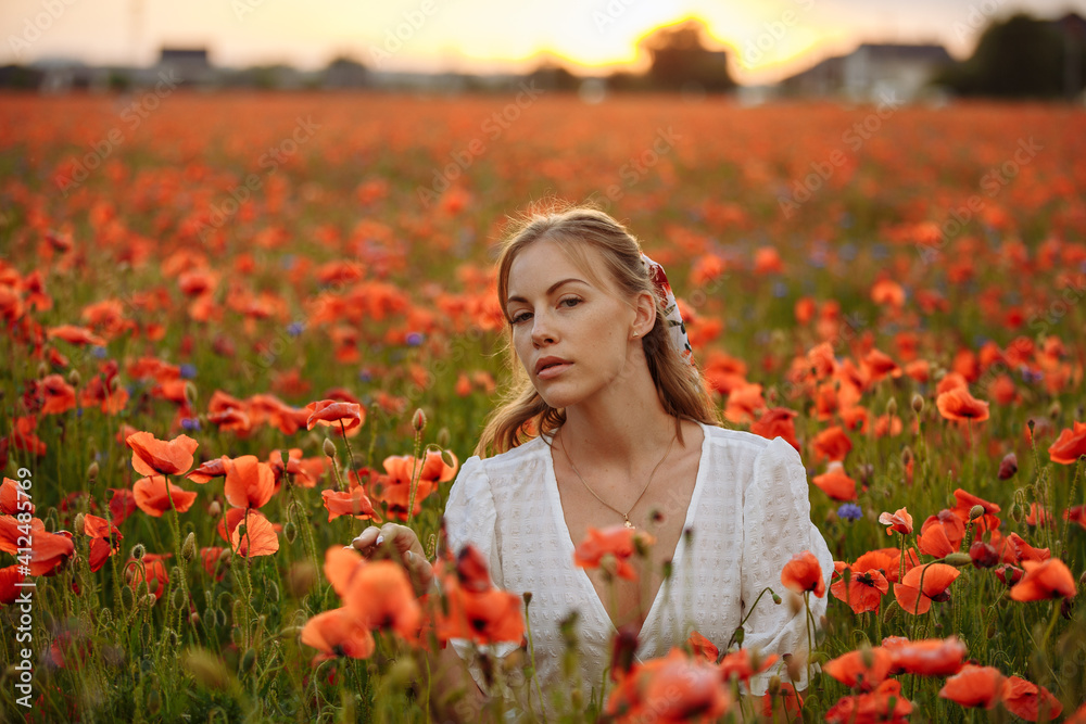 a girl in a white dress posing in a field with poppies a girl in a white dress posing in a field with poppies