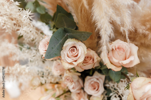 Floristic composition of cream roses, eucalyptus twigs, pampas grass and dahlia