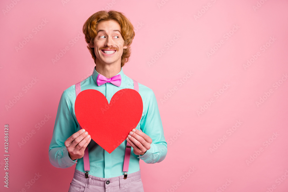 Photo of young happy smiling cheerful good mood gentleman look copyspace hold big red heart isolated on pink color background