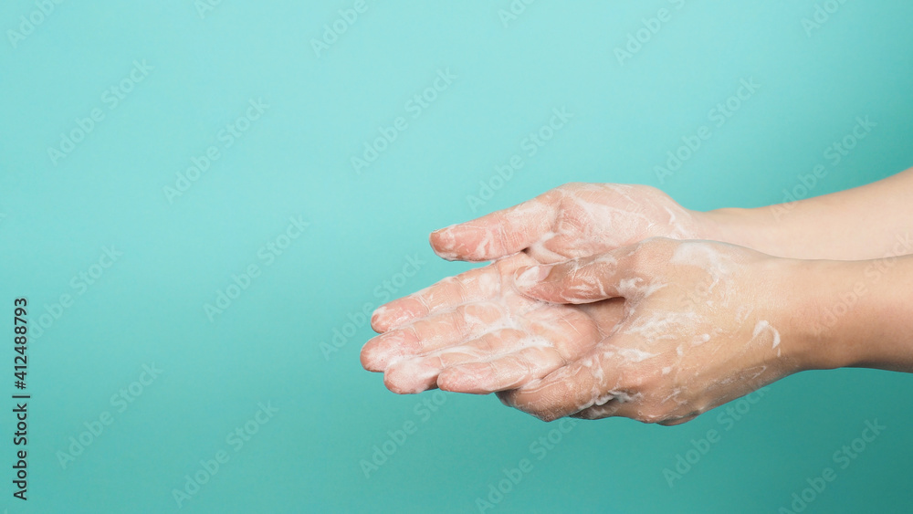 Fototapeta premium Hands washing gesture with foaming hand soap on green and Tiffany Blue background.