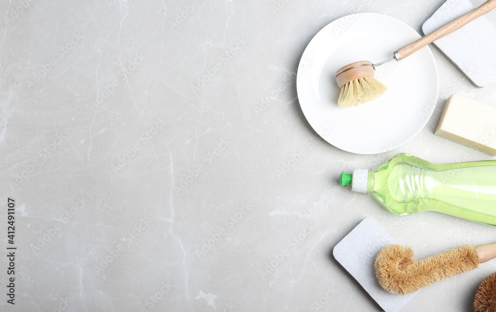Flat lay composition with cleaning product and tools on grey table, space for text. Dish washing supplies Flat lay composition with cleaning product and tools on grey table, space for text. Dish washing supplies