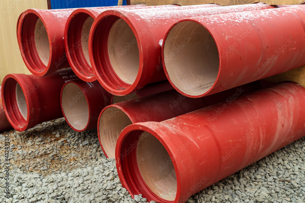 Orange ceramic water pipes are stacked on the street during renovation work Orange ceramic water pipes are stacked on the street during renovation work