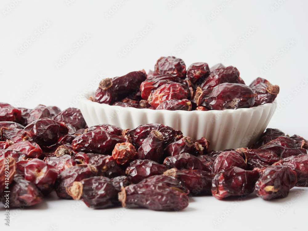Dried berries of Dog Rose or Rosa canina. Dry fruits of sweet-brier or rose hips on wooden background. Healthy and herbal concept. Selective focus. Natural vitamin, nutritional supplement for health Dried berries of Dog Rose or Rosa canina. Dry fruits of sweet-brier or rose hips on wooden background. Healthy and herbal concept. Selective focus. Natural vitamin, nutritional supplement for health
