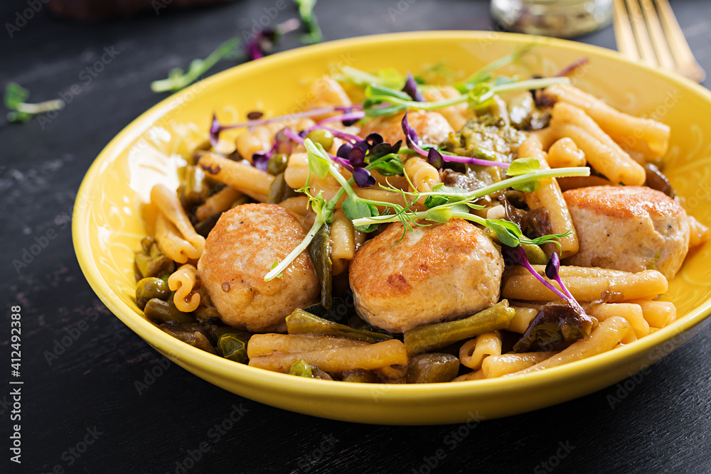 Caserecce pasta with meatballs in sweet and sour sauce and vegetables in bowl. Caserecce pasta with meatballs in sweet and sour sauce and vegetables in bowl.