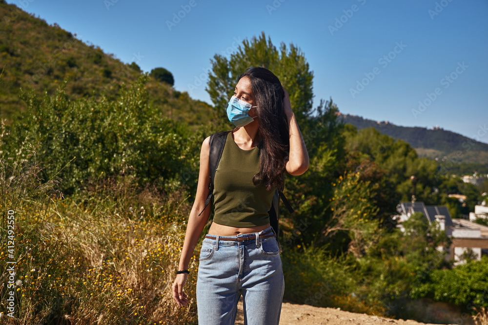 Carefree lady standing outside holding her hair
