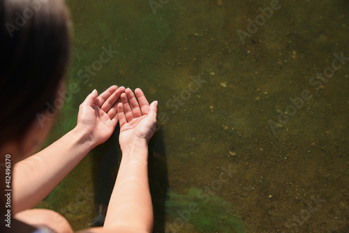 Woman taking pure water from river, closeup. Nature healing power
