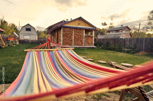 Close-up of a hammock stretched out in the backyard of a country house.