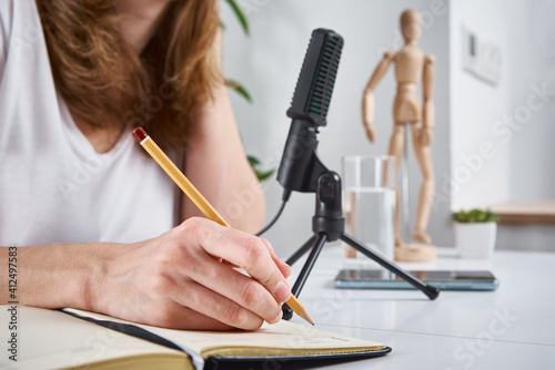 Woman recording online podcast at home. Microphone on table. home studio workplace