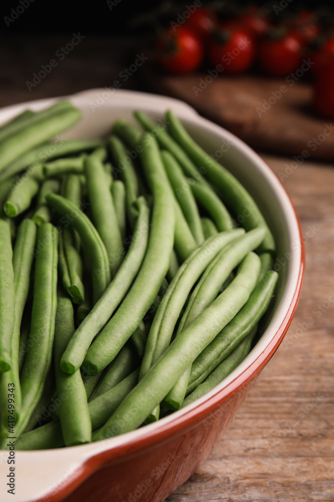 Raw green beans in baking dish on wooden table, closeup Raw green beans in baking dish on wooden table, closeup