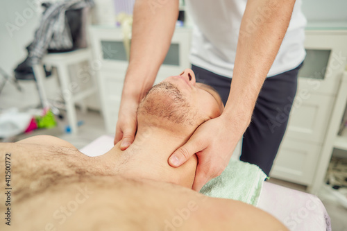 A man on a massage table receives a treatment from a professional.