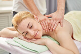 The male hands of a professional massage the woman's back. Therapeutic back massage for spinal scoliosis.