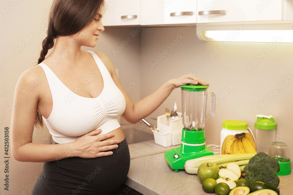 Young pregnant woman make a green healthy smoothie Young pregnant woman make a green healthy smoothie