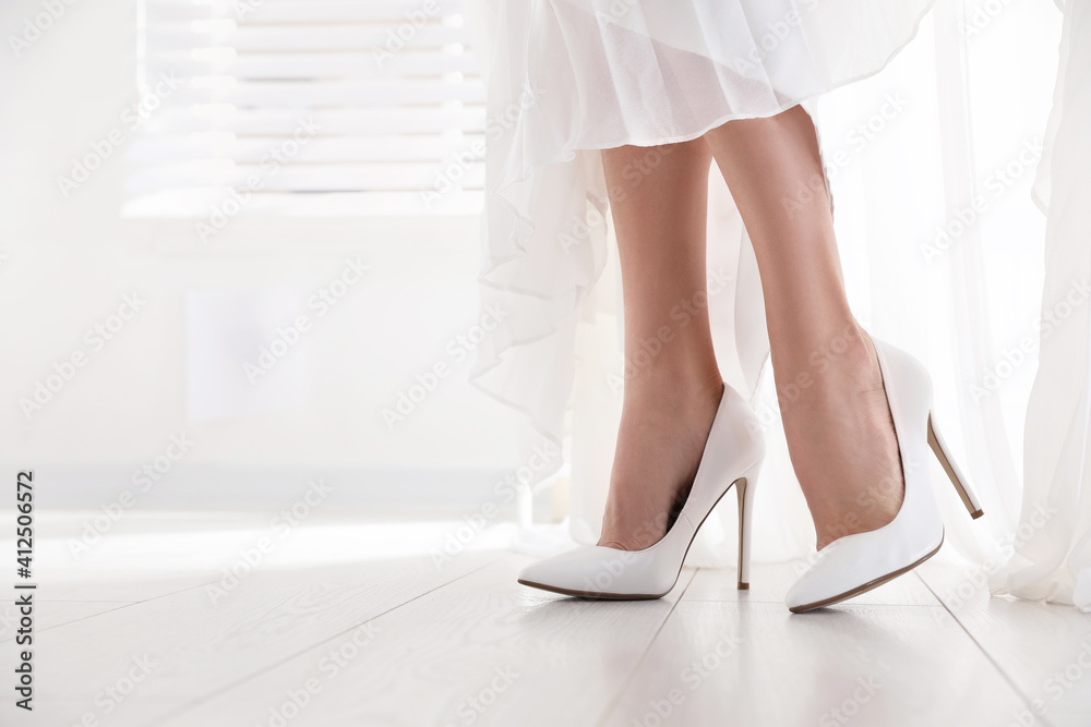 Young bride in beautiful wedding shoes walking indoors, closeup Young bride in beautiful wedding shoes walking indoors, closeup