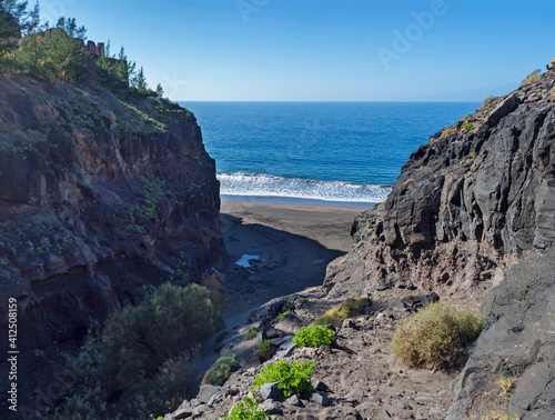 Mouth of Barranco de Guigui Grande gorge with view of empty sand beach Playa de Guigui in west part of the Gran Canaria island, accessible only on foot or by boat. Canary Islands, Spain