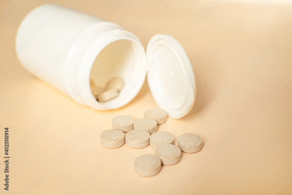 Medicine bottle with tablets. Pills from bottle on the peach background. Brewer's yeast with zinc. Medicine bottle with tablets. Pills from bottle on the peach background. Brewer's yeast with zinc.