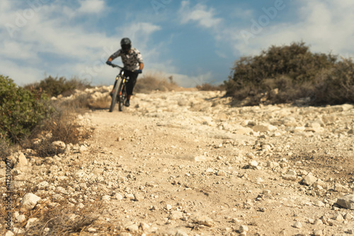 Professional bike rider during downhill ride on his bicycle