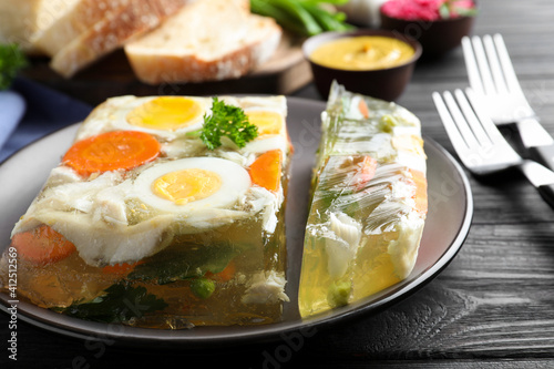 Delicious fish aspic served on black wooden table, closeup