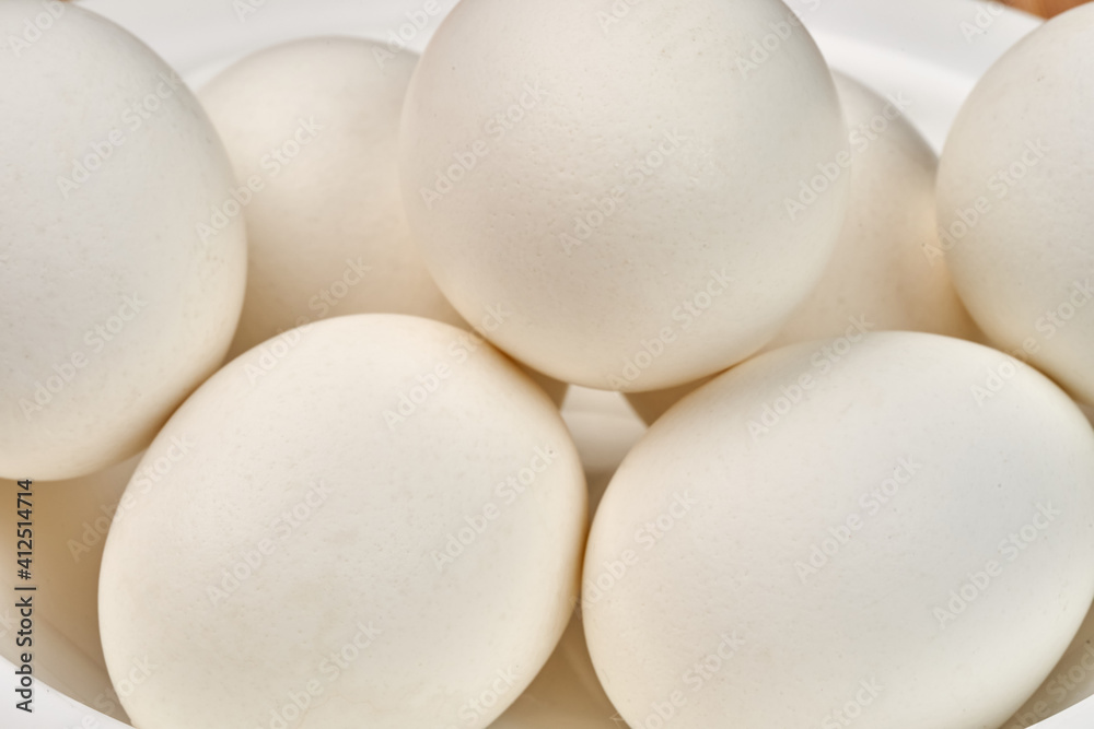 White clean chicken eggs in a plate. Close-up. Selective focus White clean chicken eggs in a plate. Close-up. Selective focus