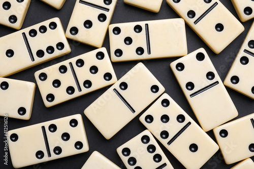 Classic domino tiles on black background  flat lay