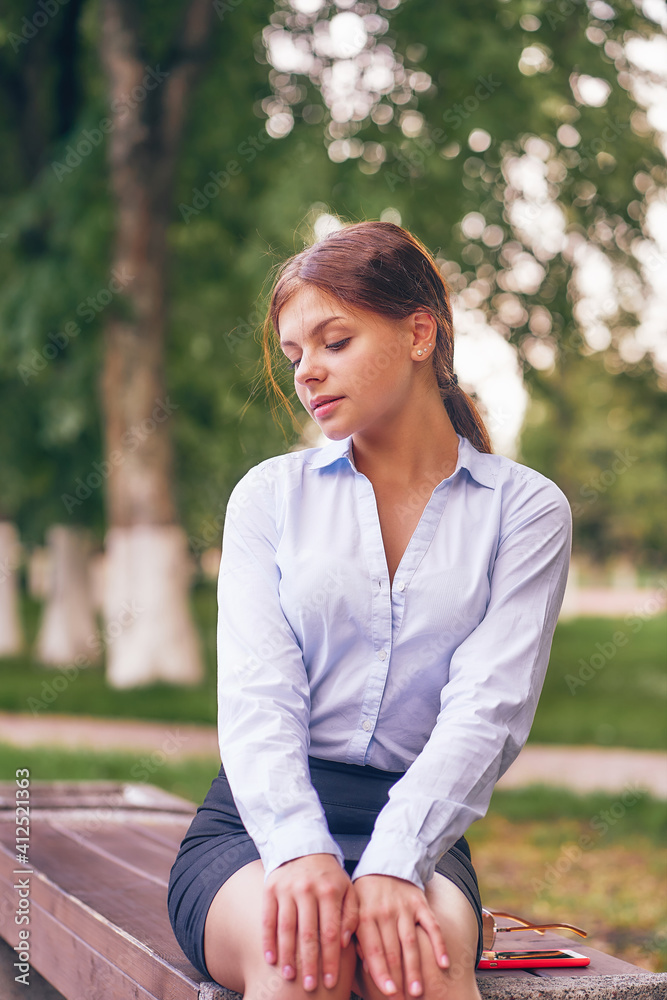 office worker on a bench in a city park. vertical office worker on a bench in a city park. vertical
