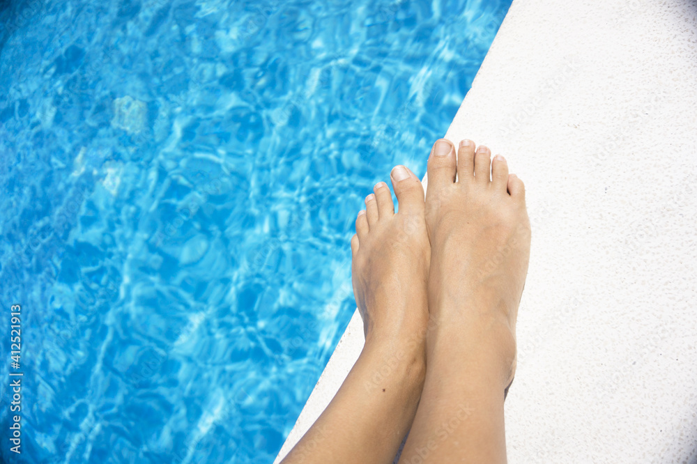 Slim legs of young woman in swimming pool