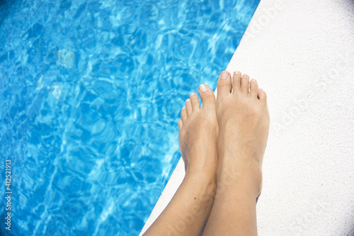 Slim legs of young woman in swimming pool